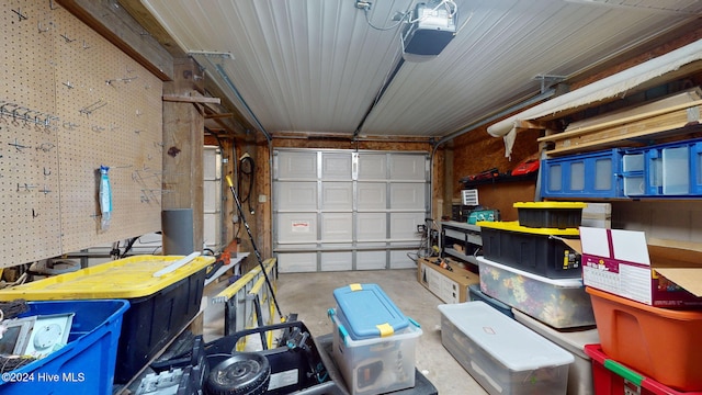 garage with wood walls and a garage door opener