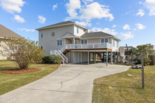 back of property featuring covered porch, a yard, a garage, and a carport