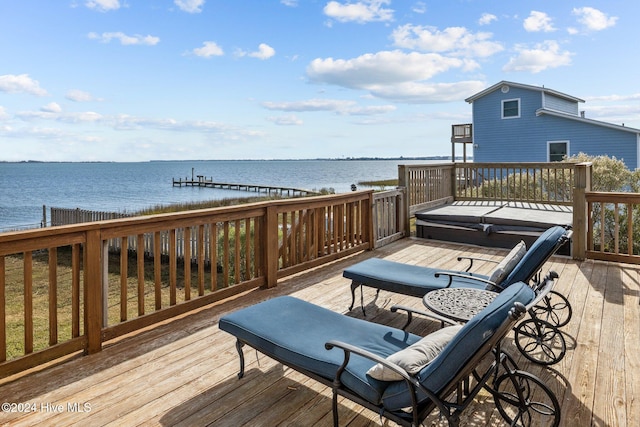 wooden terrace featuring a water view and a covered hot tub