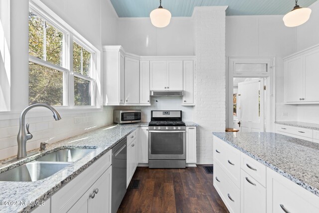 950 Main St, Fair Bluff, NC 28439 - kitchen featuring appliances with stainless steel finishes, a sink, under cabinet range hood, white cabinets, and tasteful backsplash
