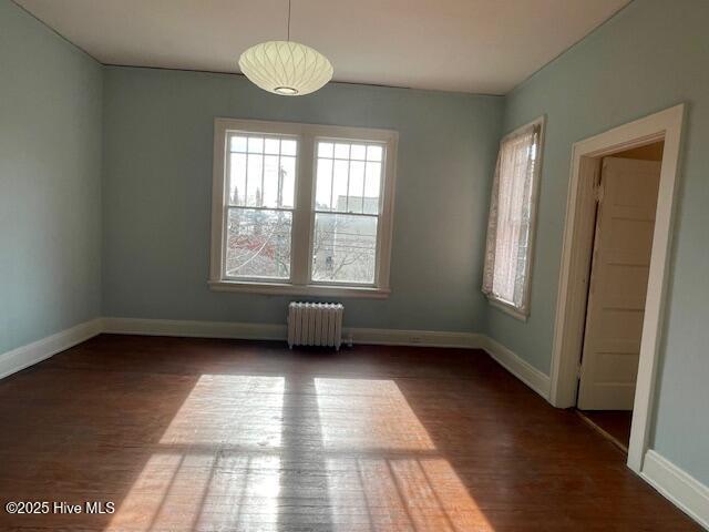 4290 W Church St, Farmville, NC 27828 - unfurnished dining area featuring radiator, baseboards, and wood finished floors