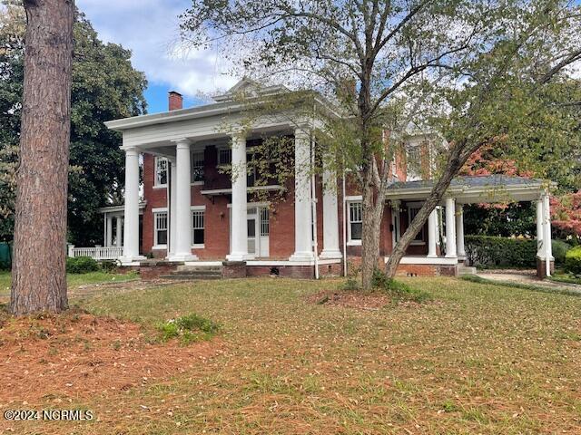4290 W Church St, Farmville, NC 27828 - neoclassical home featuring a chimney, a porch, and a front yard