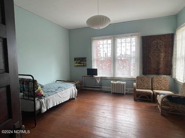 bedroom featuring radiator heating unit and dark hardwood / wood-style floors