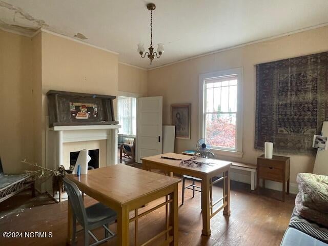 dining area with a notable chandelier, dark wood-type flooring, and crown molding