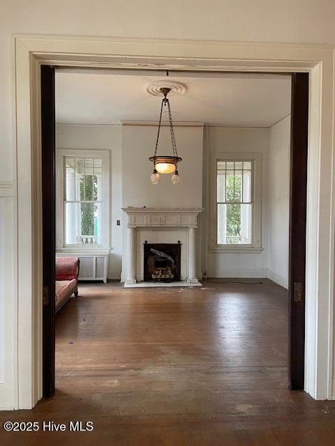 4290 W Church St, Farmville, NC 27828 - unfurnished living room featuring baseboards, a fireplace with flush hearth, wood finished floors, and ornamental molding