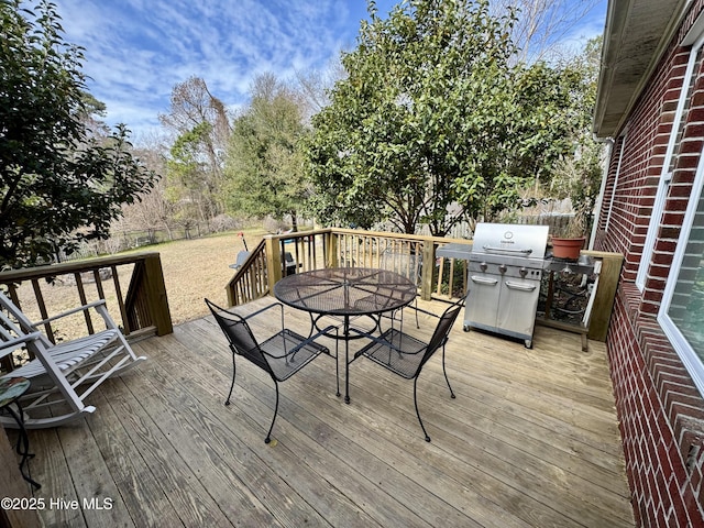 wooden deck featuring a grill, outdoor dining space, and fence