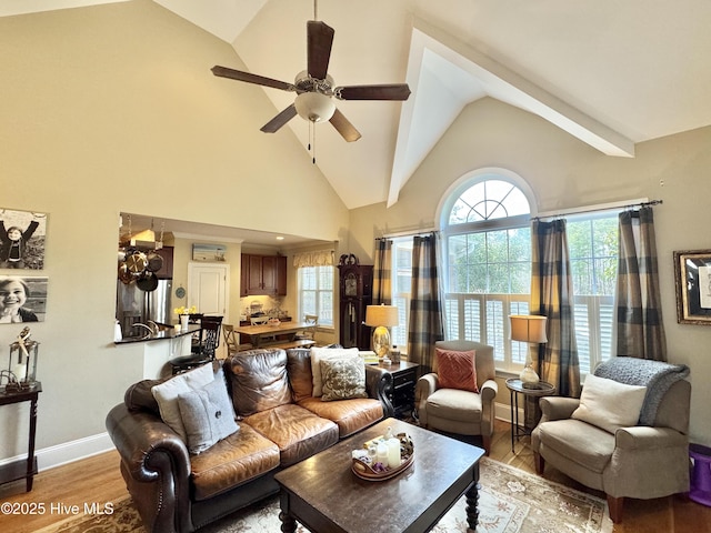 living area featuring baseboards, high vaulted ceiling, light wood-style flooring, and a ceiling fan