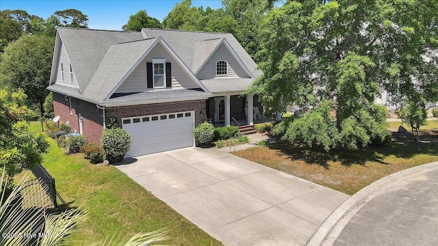 5800 Neelys Ct, Wilmington, NC 28409 - view of front of house featuring driveway, a garage, brick siding, covered porch, and a front lawn