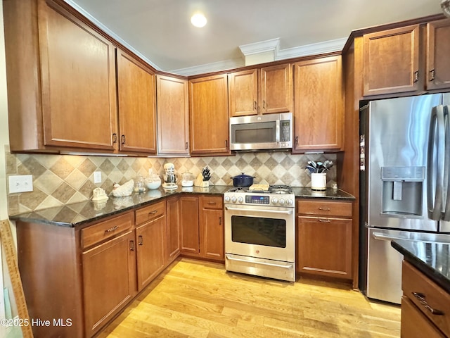 kitchen featuring dark stone countertops, brown cabinets, and appliances with stainless steel finishes