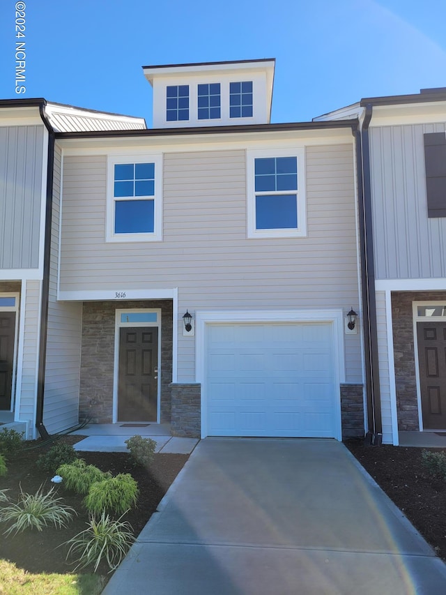 view of front of home with stone siding, board and batten siding, a garage, and driveway