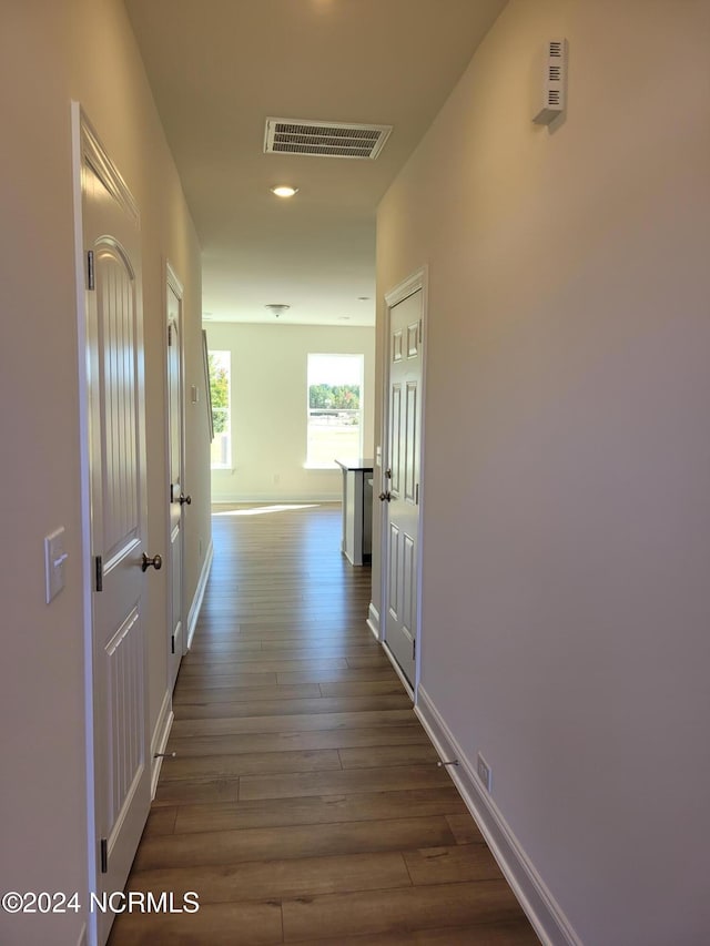 hallway with dark wood finished floors and baseboards