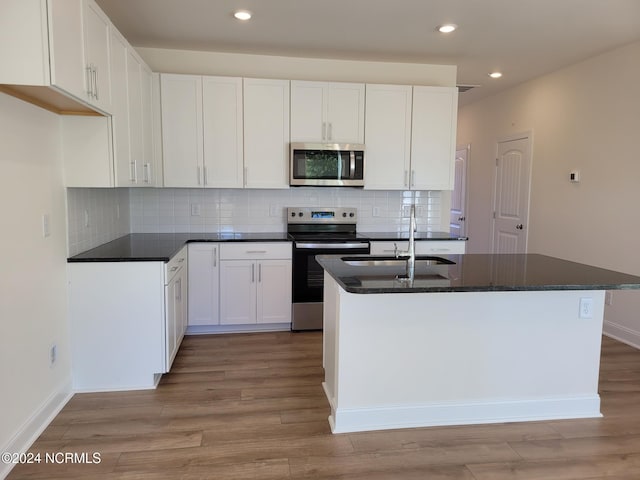 kitchen featuring appliances with stainless steel finishes, a sink, white cabinets, and recessed lighting