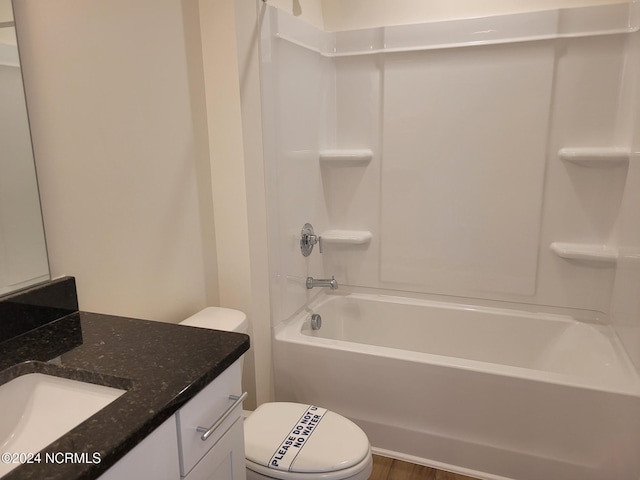 bathroom with toilet, vanity, and  shower combination