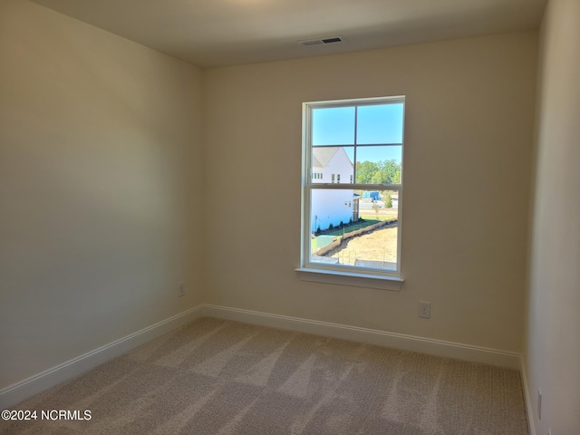 carpeted empty room featuring baseboards