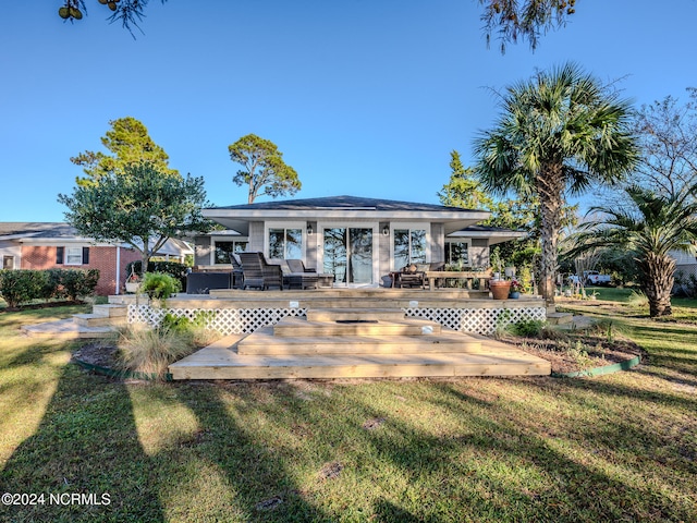 back of property featuring a deck and a yard