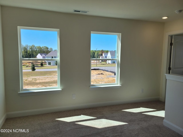unfurnished room with healthy amount of natural light, carpet, baseboards, a smoke detector, and recessed lighting