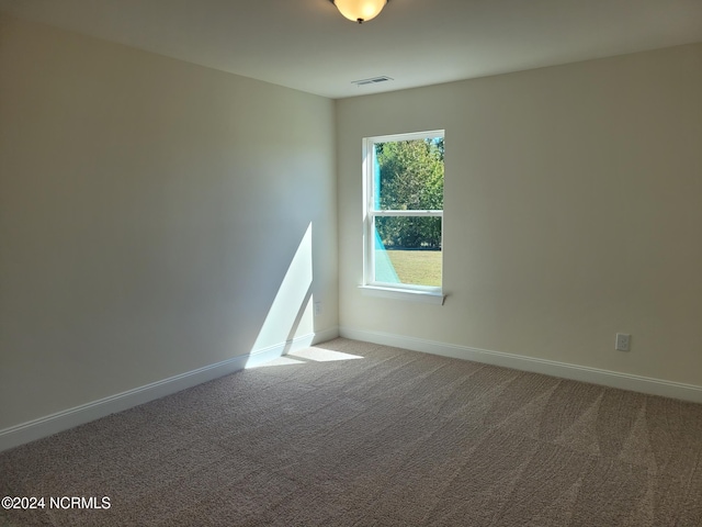 spare room with baseboards and carpet floors