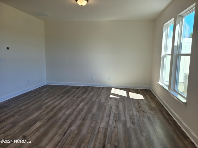 empty room with dark wood-style floors and baseboards