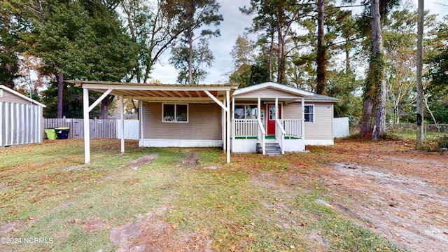 view of front of home featuring a storage unit, a front lawn, and covered porch