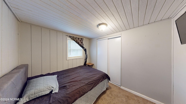 carpeted bedroom featuring a closet and wooden ceiling