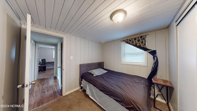 bedroom featuring carpet and wood walls