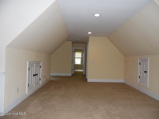 additional living space with vaulted ceiling and light colored carpet