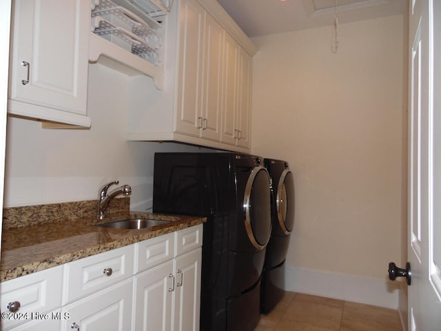 laundry room featuring light tile patterned flooring, cabinets, sink, and washing machine and clothes dryer