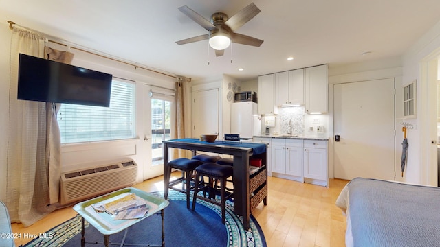 kitchen with sink, ceiling fan, light hardwood / wood-style flooring, white cabinets, and white refrigerator