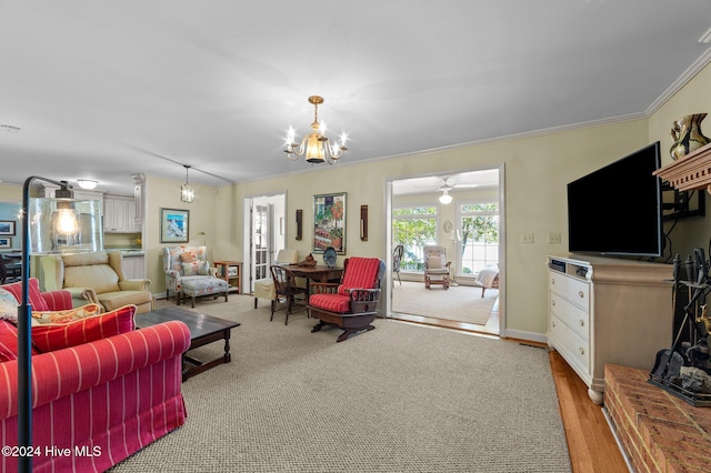 living room featuring crown molding, hardwood / wood-style flooring, and ceiling fan with notable chandelier