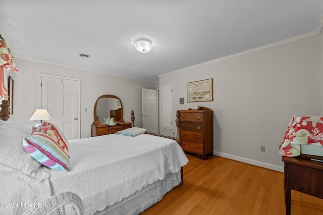 bedroom featuring a closet, ornamental molding, and light wood-type flooring