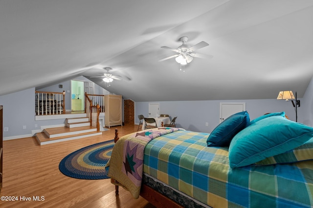 bedroom with hardwood / wood-style floors, ceiling fan, and vaulted ceiling