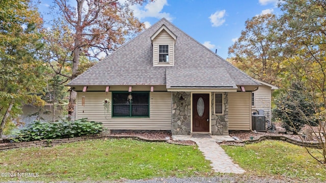 bungalow-style house featuring a front yard and central air condition unit