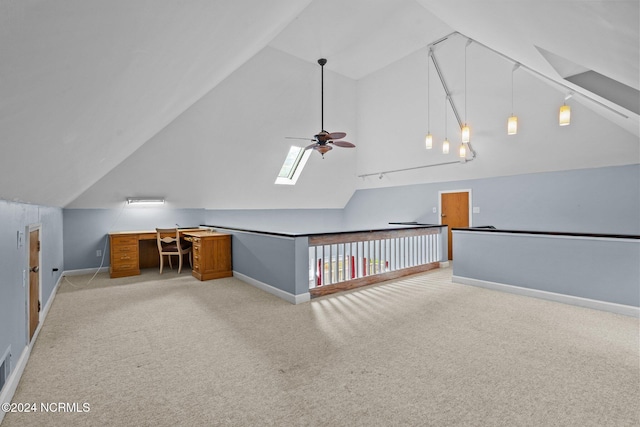 additional living space with lofted ceiling with skylight, light colored carpet, and ceiling fan