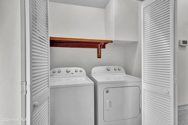 washroom with independent washer and dryer and a textured ceiling