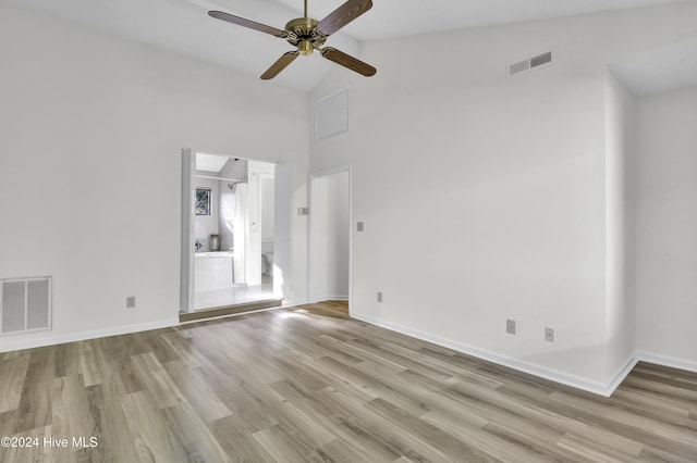 spare room with light hardwood / wood-style flooring, high vaulted ceiling, and ceiling fan