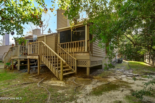 back of property with cooling unit, a sunroom, and a deck