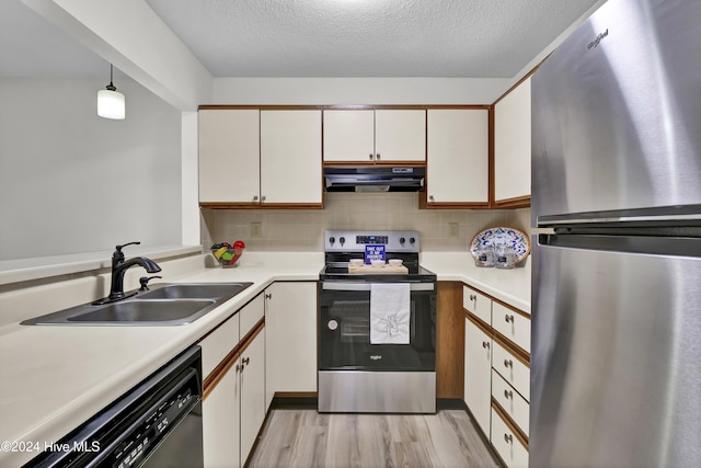 kitchen with ventilation hood, sink, white cabinets, hanging light fixtures, and stainless steel appliances