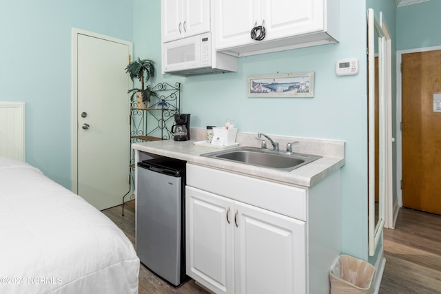 kitchen featuring sink, white cabinetry, stainless steel refrigerator, and dark hardwood / wood-style flooring