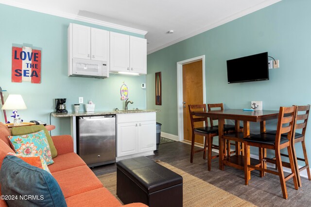 interior space featuring dark wood-type flooring, sink, crown molding, stainless steel dishwasher, and white cabinetry