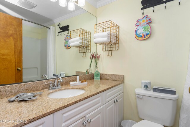 bathroom with vanity, ornamental molding, and toilet