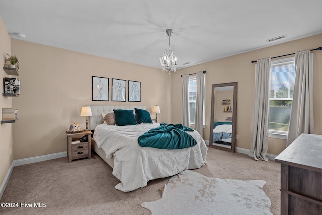 carpeted bedroom featuring a notable chandelier and multiple windows