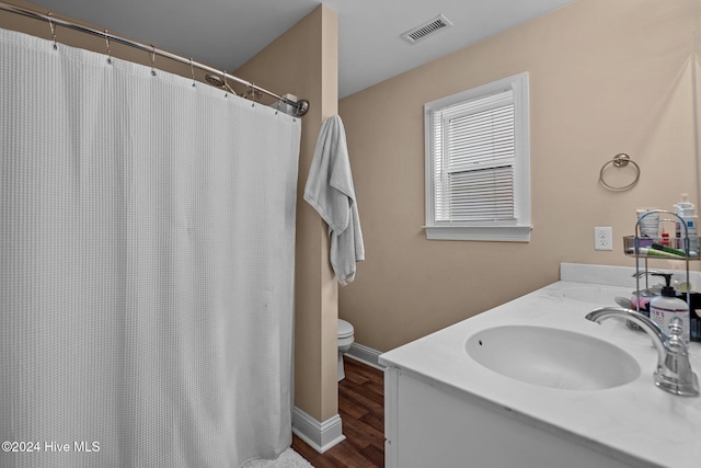 bathroom featuring hardwood / wood-style floors, vanity, curtained shower, and toilet