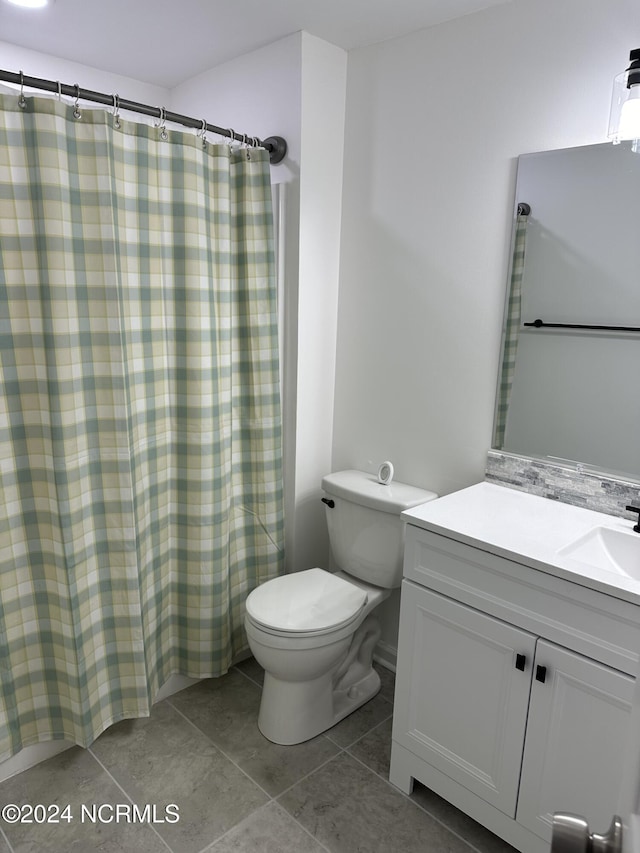 bathroom featuring a shower with curtain, vanity, tile patterned floors, and toilet