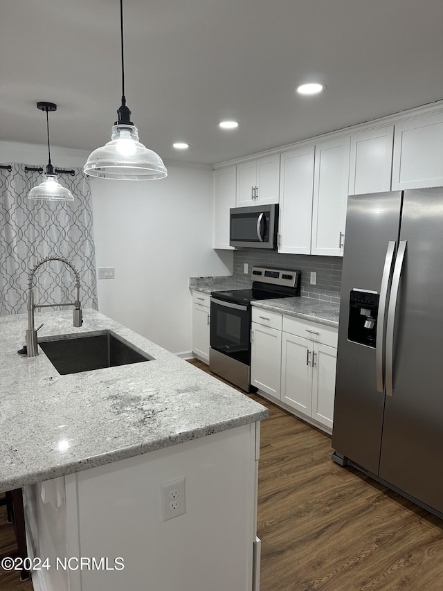 kitchen featuring sink, stainless steel appliances, light stone counters, white cabinets, and decorative light fixtures