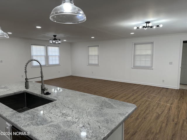 kitchen featuring dark hardwood / wood-style floors, sink, pendant lighting, and light stone counters