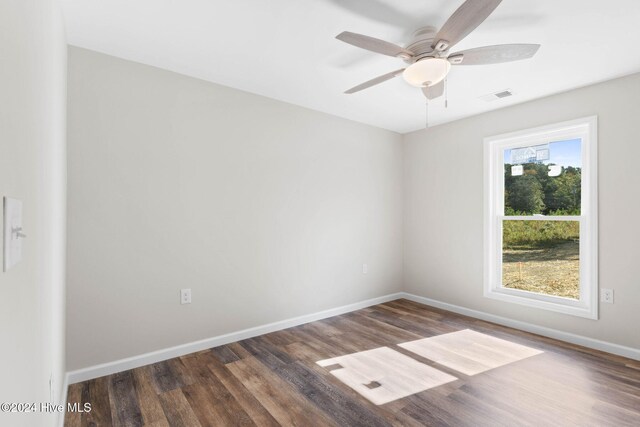 empty room with ceiling fan and dark hardwood / wood-style flooring