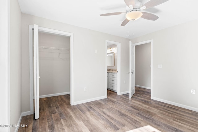 unfurnished bedroom featuring dark hardwood / wood-style flooring, ceiling fan, a closet, and ensuite bath