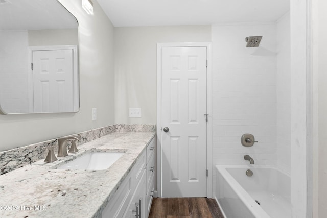 bathroom featuring hardwood / wood-style floors, vanity, and washtub / shower combination