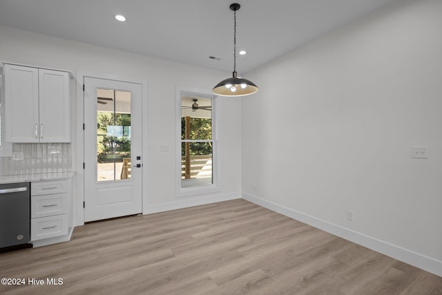 unfurnished dining area with light wood-type flooring and ceiling fan