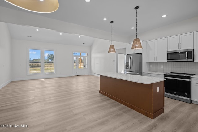 kitchen with white cabinets, a center island, light wood-type flooring, and stainless steel appliances